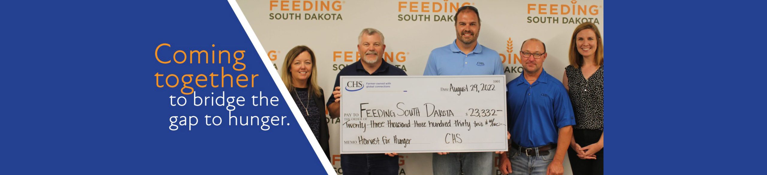 Five people holding up a check for Feeding South Dakota with a saying of Coming together to bridge the gap to hunger.