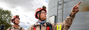 Two firefighters next to a grain bin