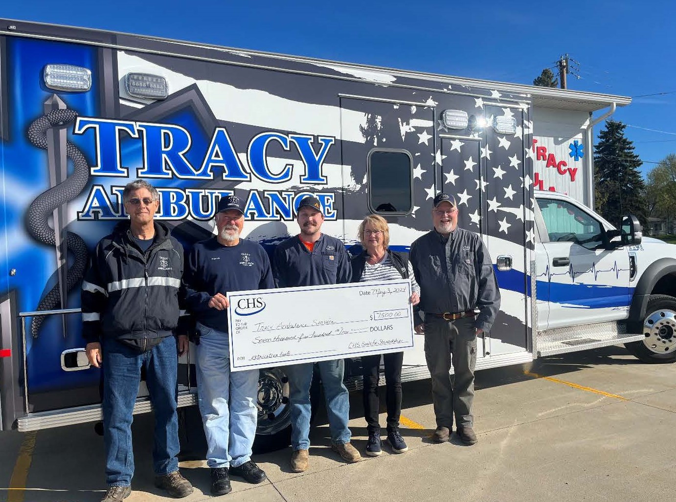 Five people holding up a check for the Tracy Ambulance