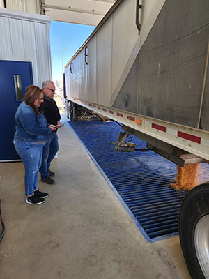two people watching corn be dumped